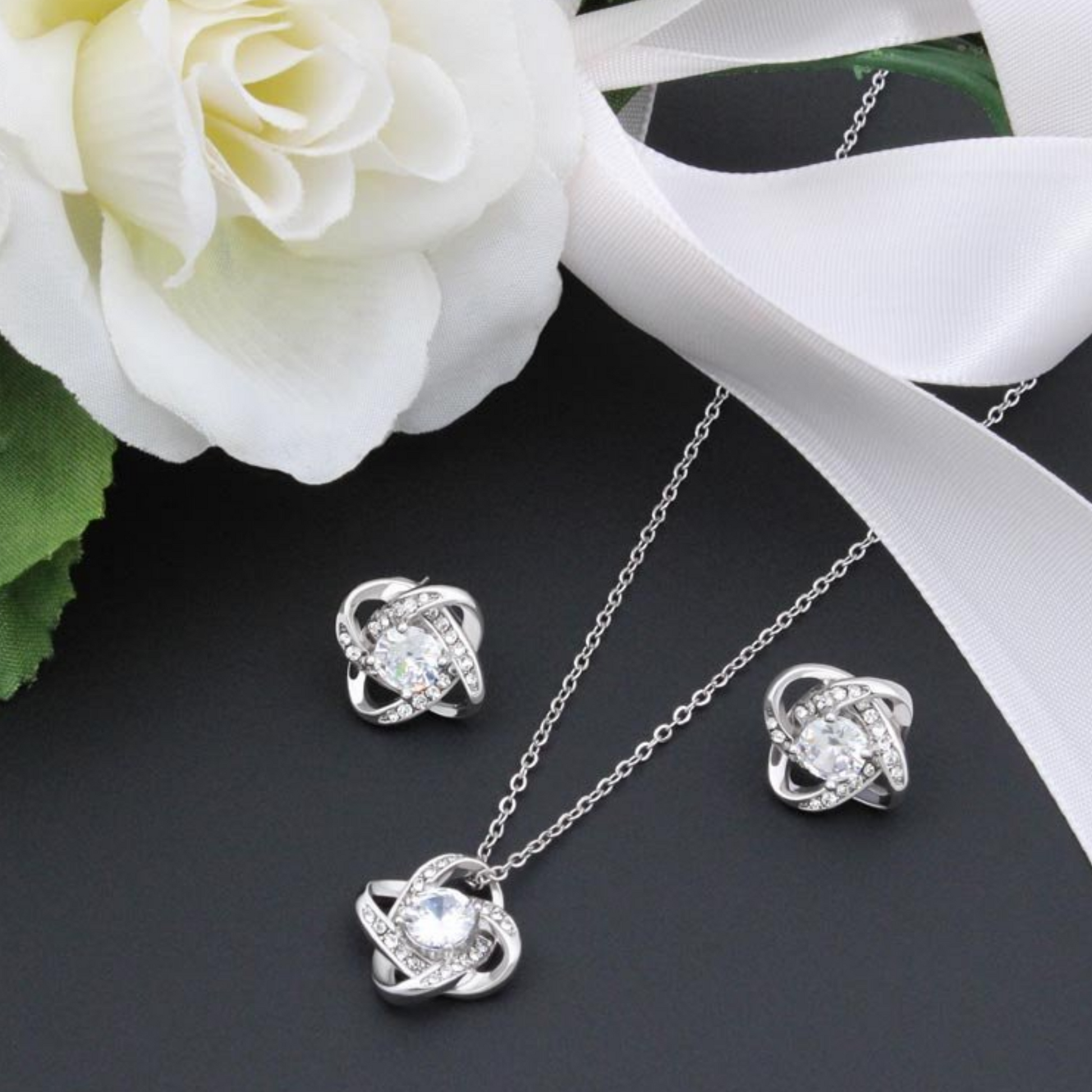 Cubic zirconia knot stud earrings in silver tone, round center with halo stones