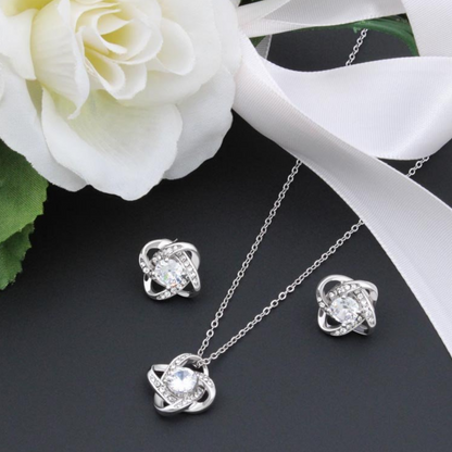 Cubic zirconia knot stud earrings in silver tone, round center with halo stones