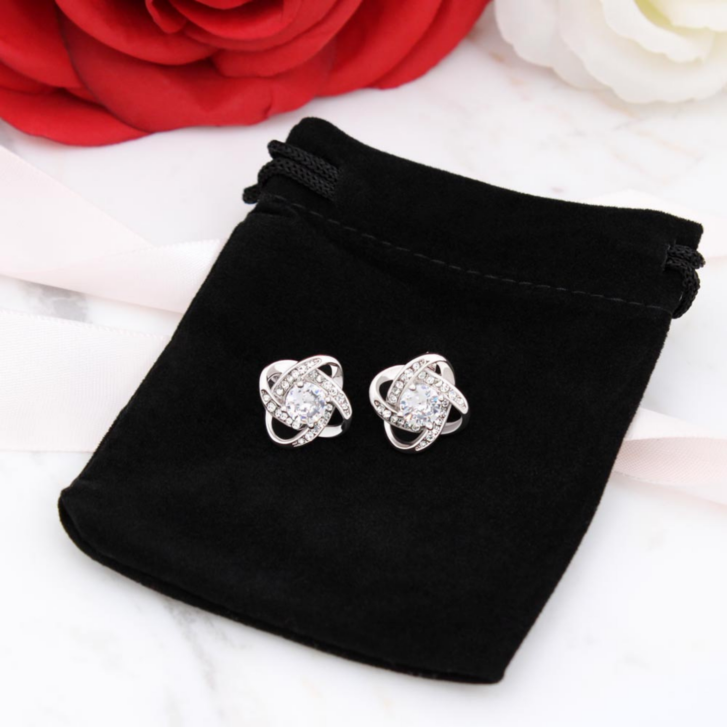 Silver-tone cubic zirconia knot stud earrings with round center stones and sparkling halos